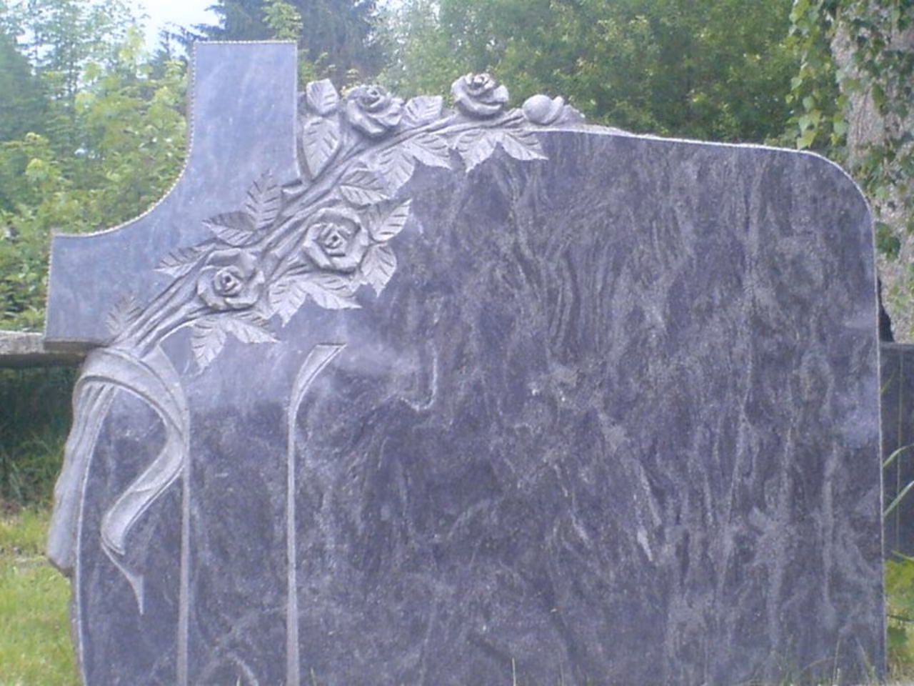 Grabstein mit Rosenrelief und Kreuz auf dem Steinplatz