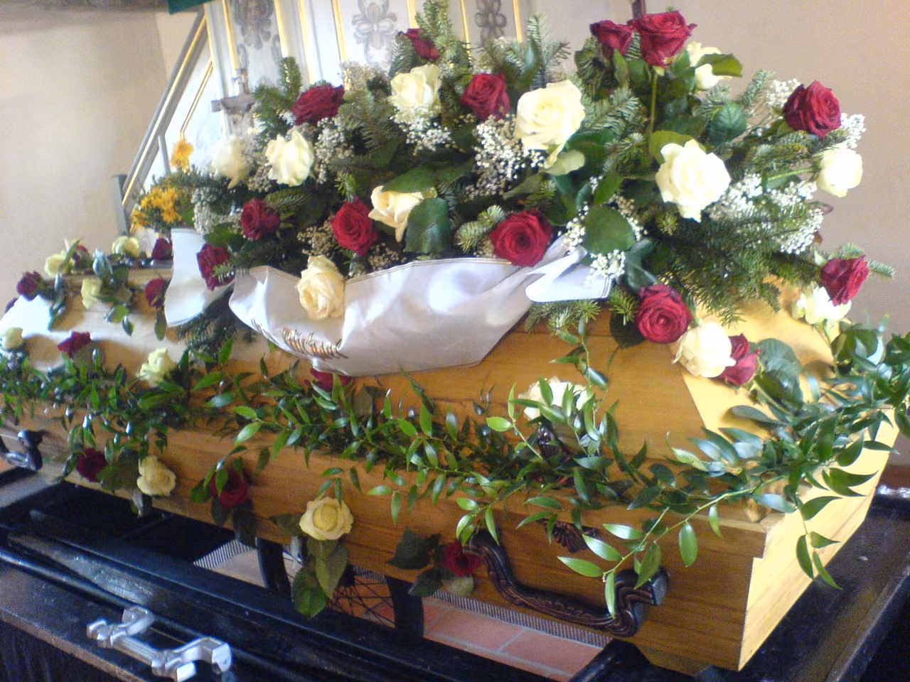 Sarg mit roten und weißen Rosen